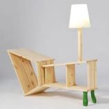 bare boards configured in an odd-shaped table with a lamp at one end and also two dark green legs.
